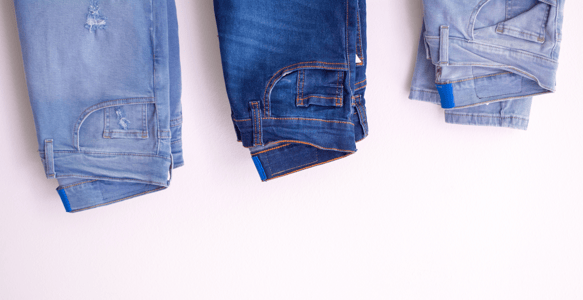 Três calças jeans de diferentes tons de azul dobradas