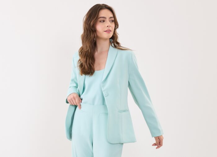 modelo dash usando look monocromatico de blazer, blusa e calça na cor verde água.